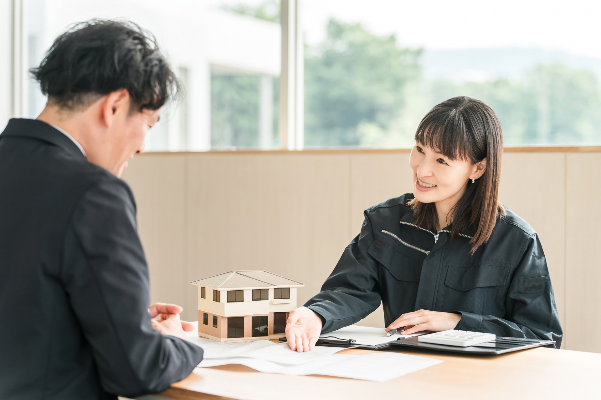 住宅模型を使って説明を行う女性
