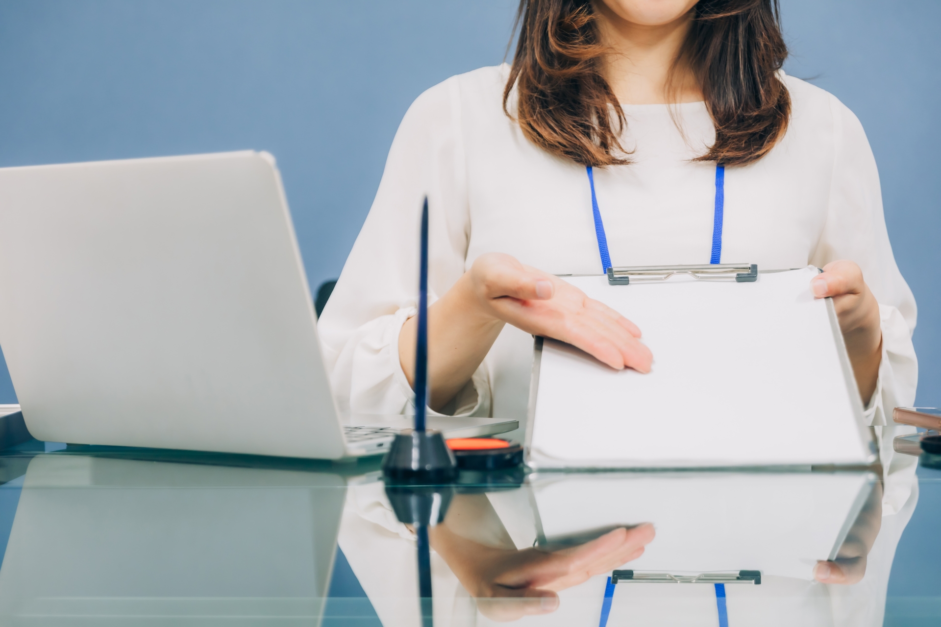 クリップボードを指す女性