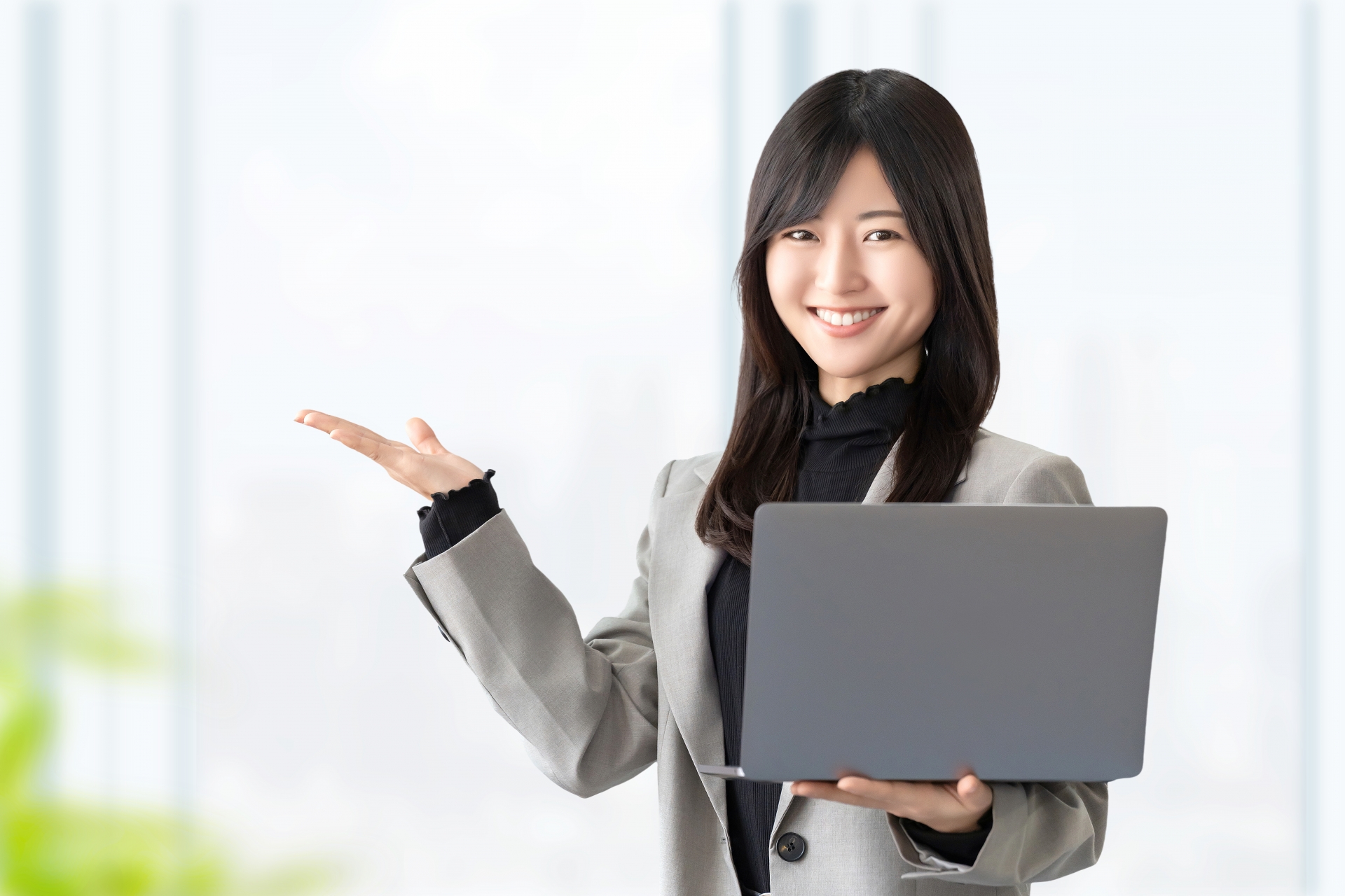 パソコンを片手に笑顔の女性