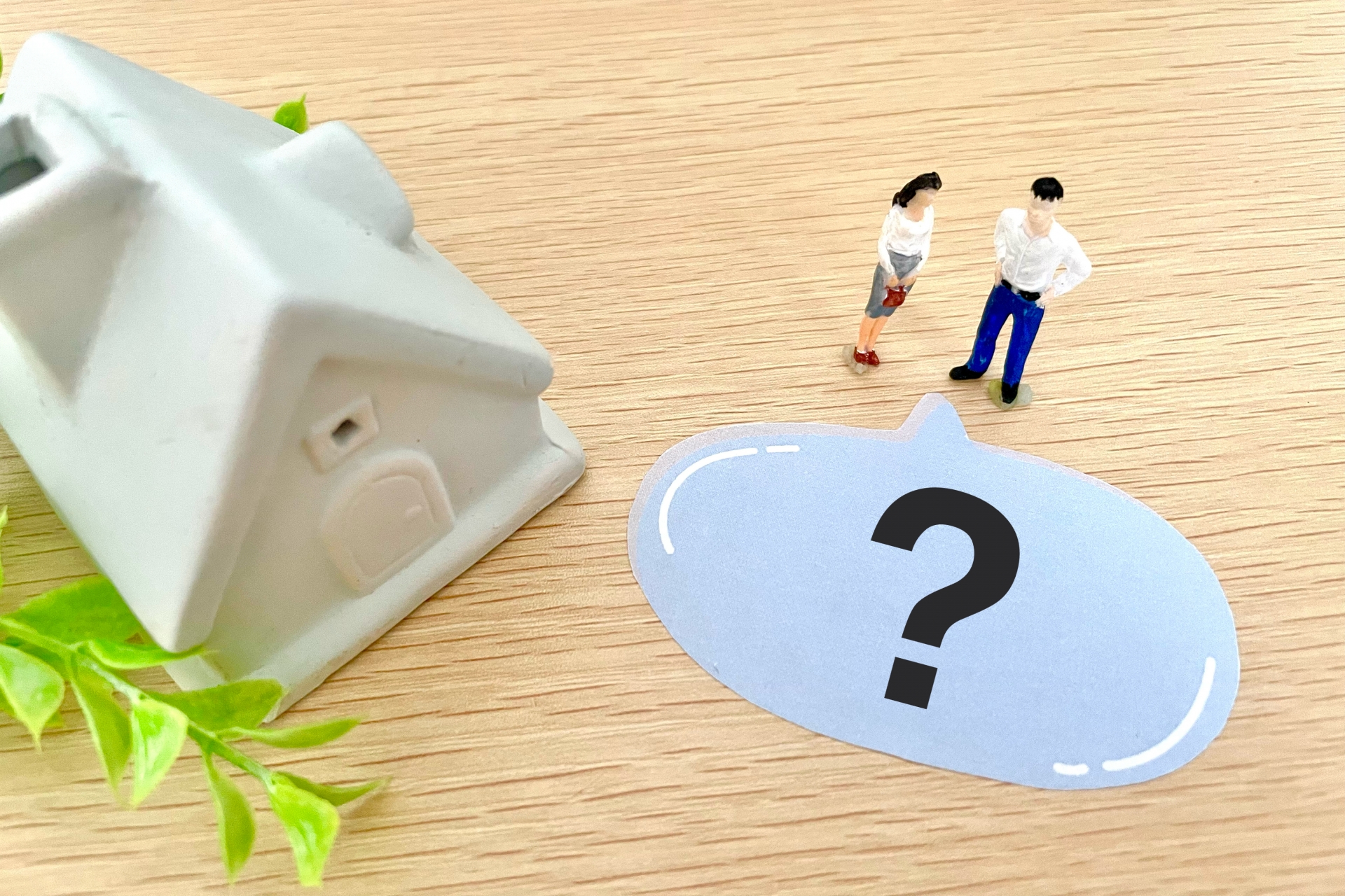 白い家の模型と2人の人形