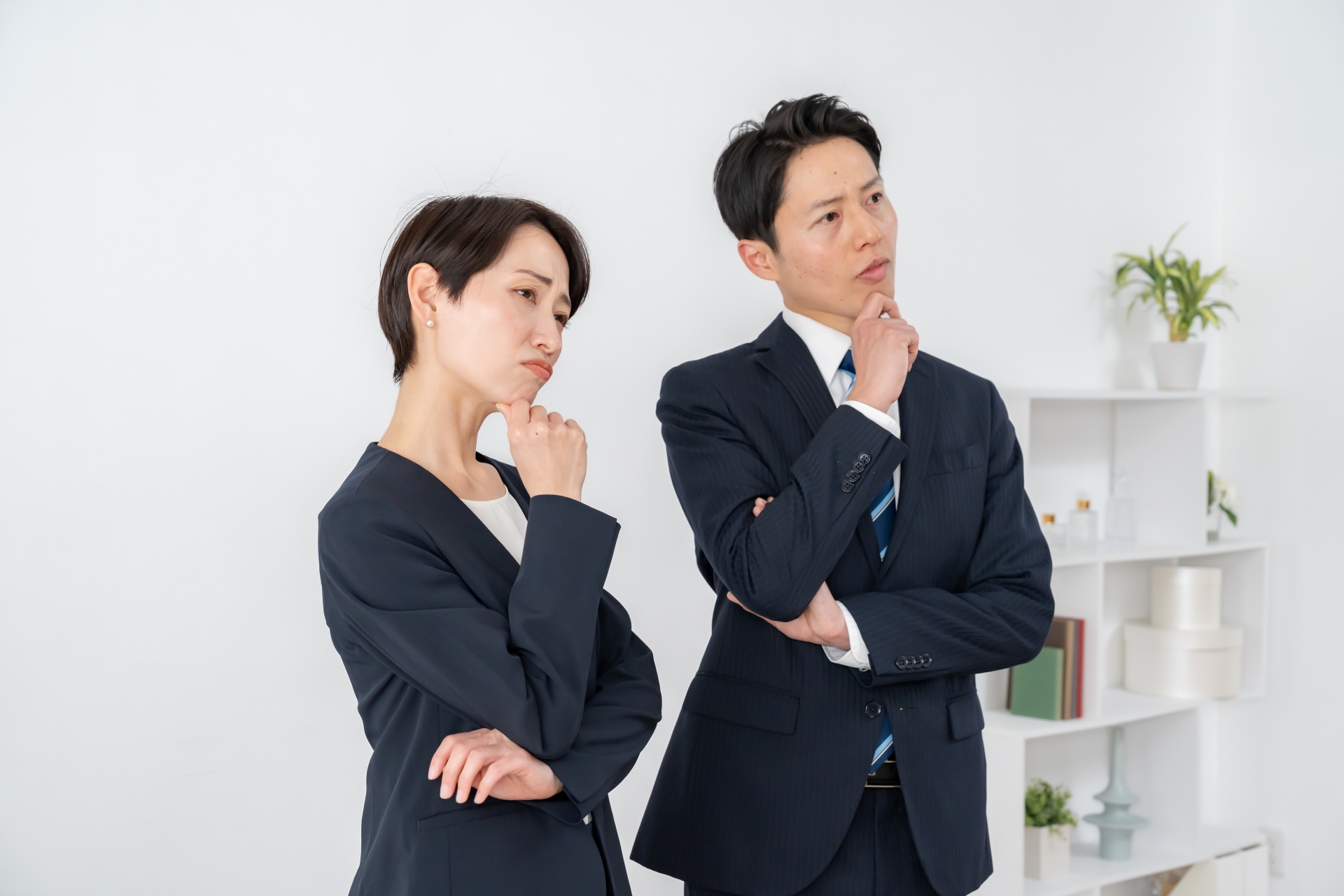 悩むスーツを着た男女