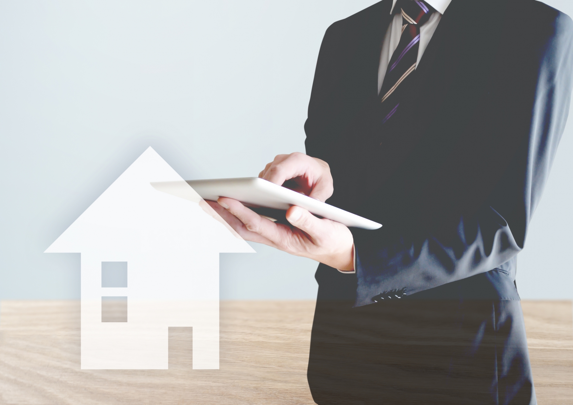 家とタブレットを持つ男性　見積もり　リサーチ