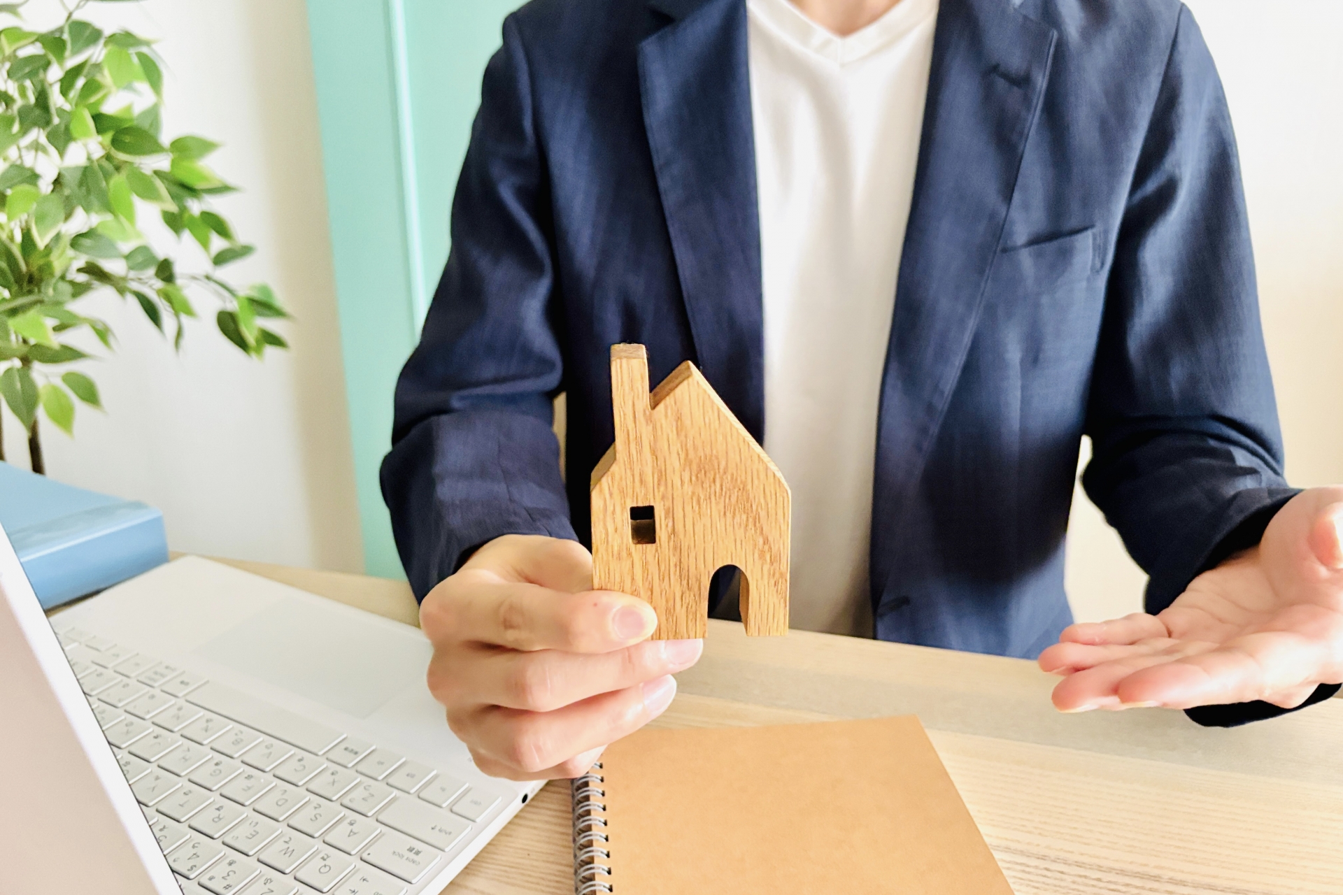家の模型を持つビジネスマン
