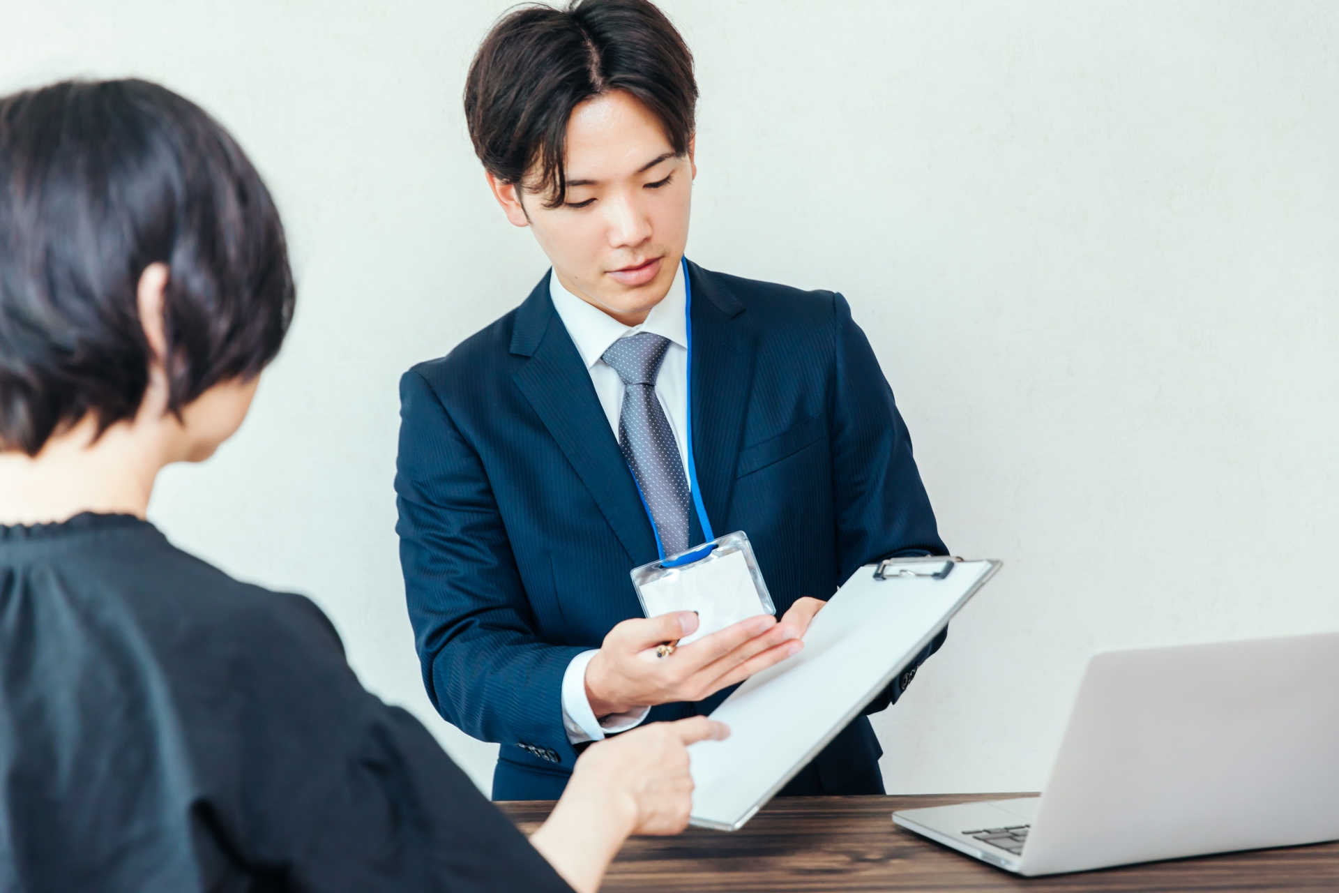 書類を見せて案内する男性会社員