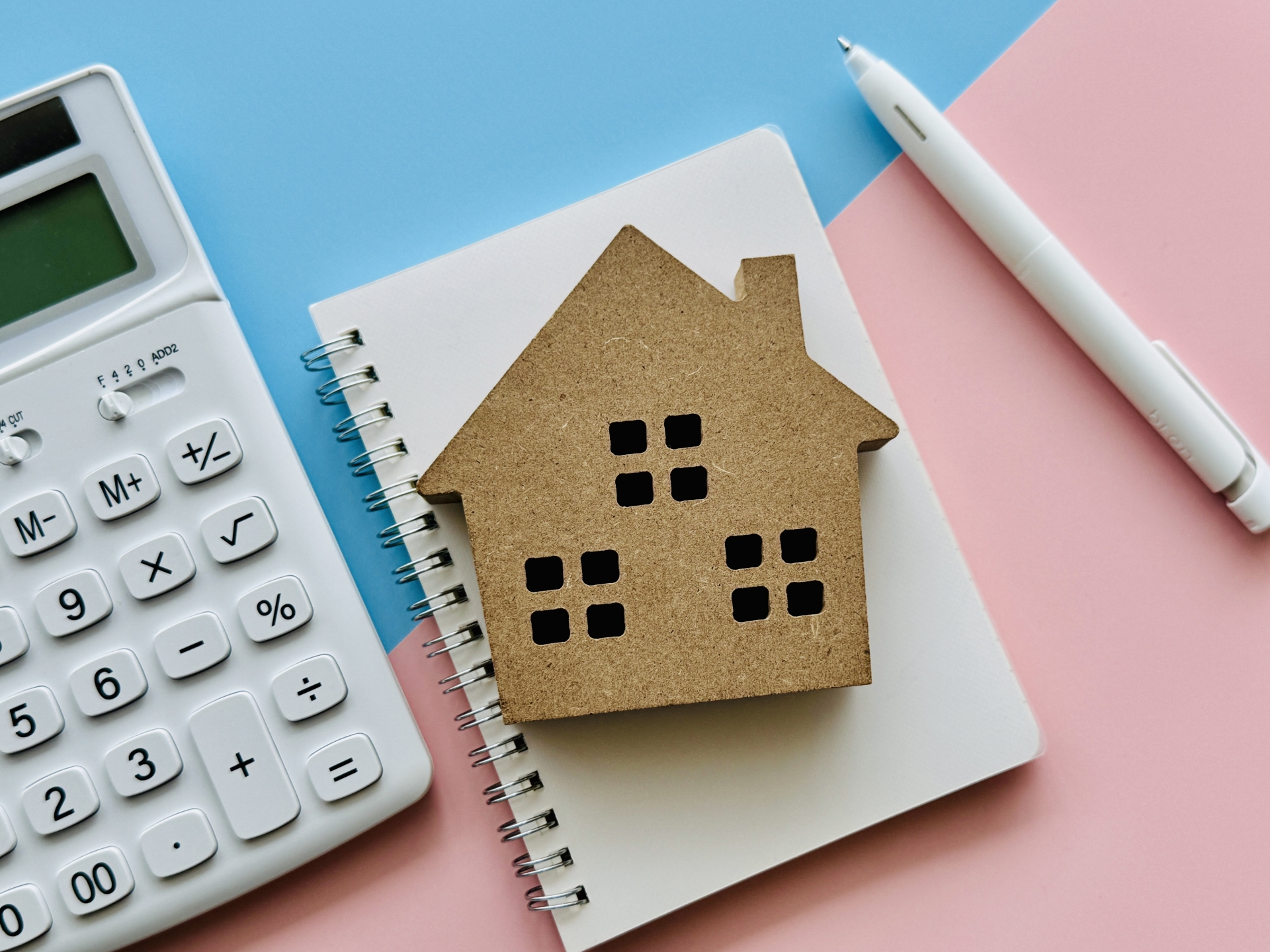家とノートと電卓（ピンク、水色背景）