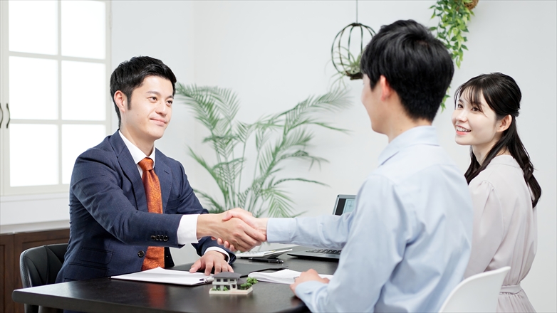 不動産の商談で握手をする男性