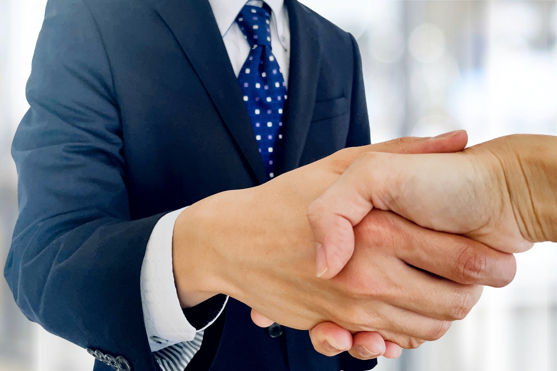 ビジネス背景とビジネスマンの握手
