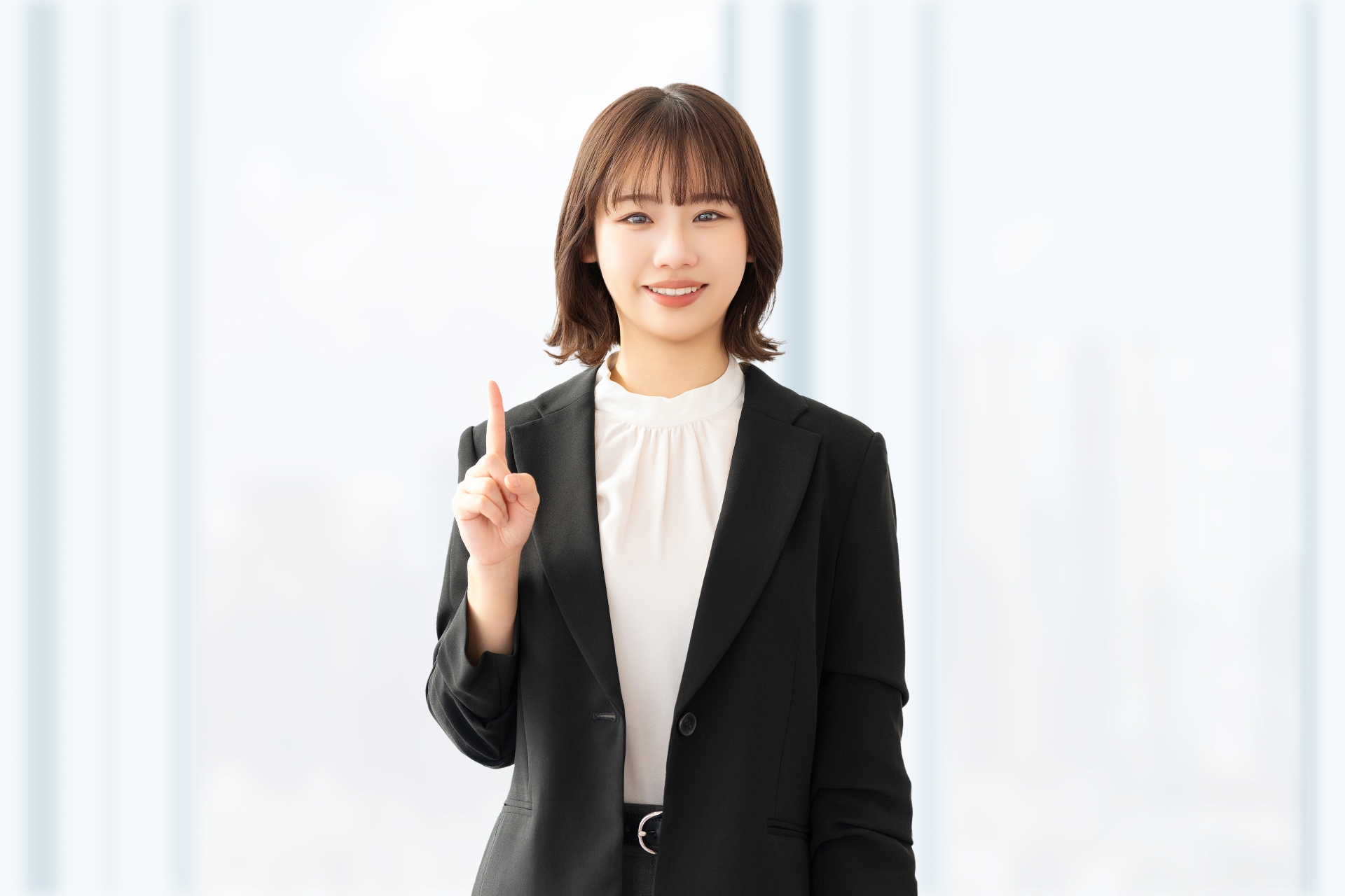人差し指を立てて案内する笑顔の女性