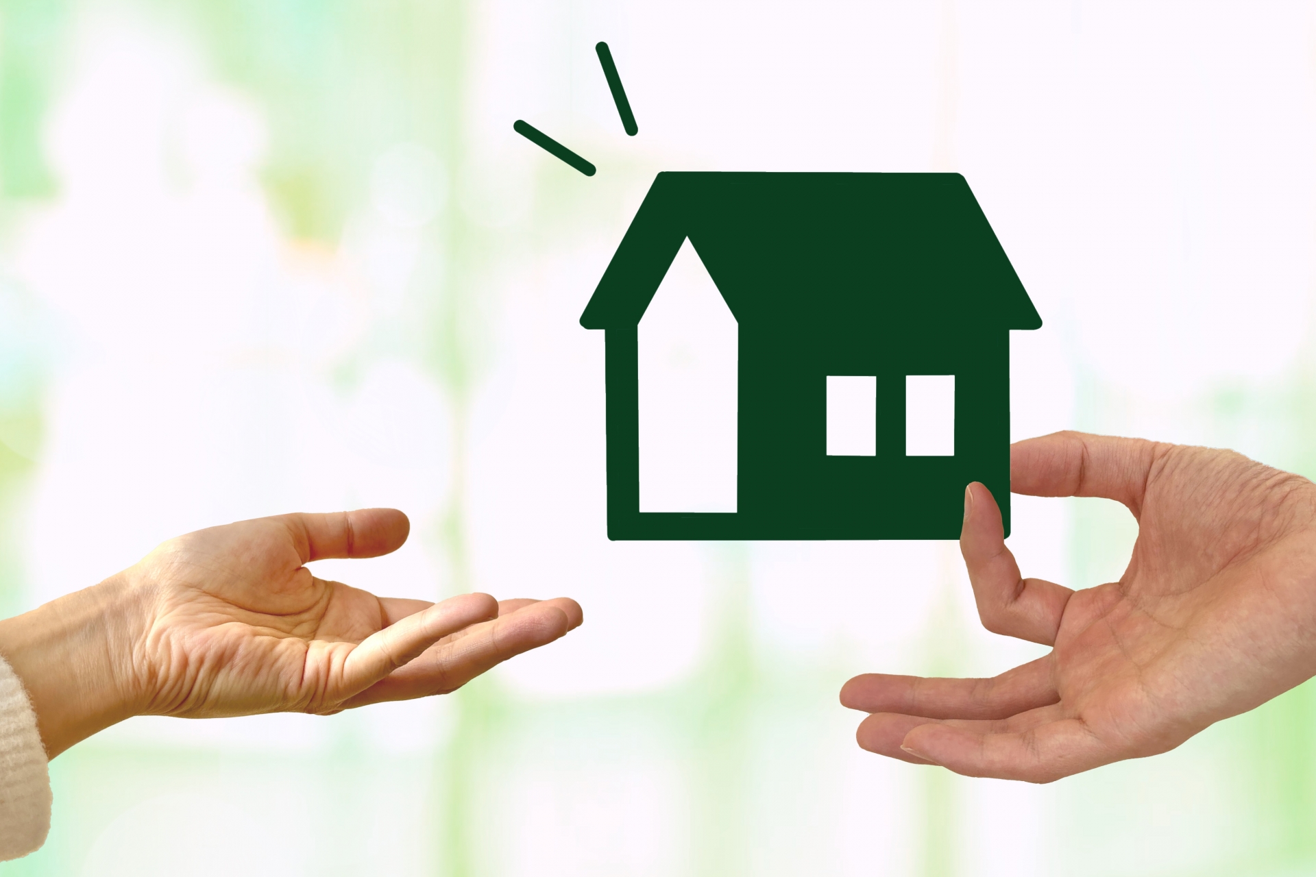 家を受け取る手とキラキラ背景