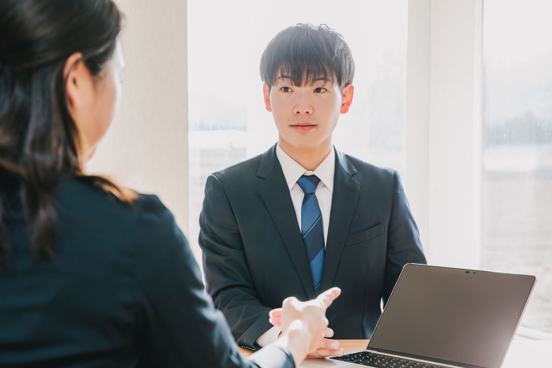 スーツを着た男性がPCを使って仕事をする