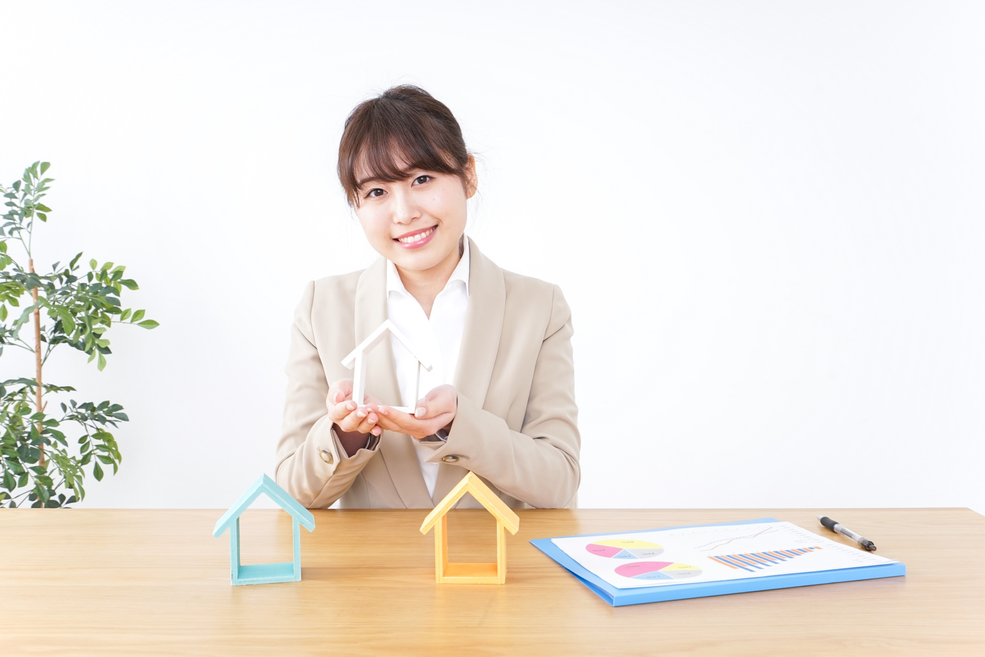 家のブロックを持って微笑む女性