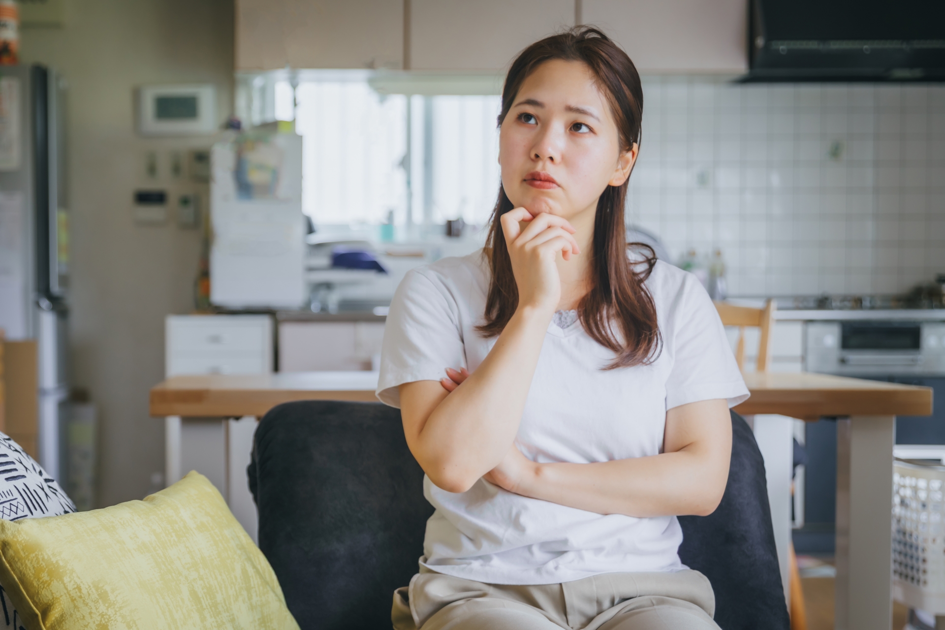 リビングのソファで考える女性