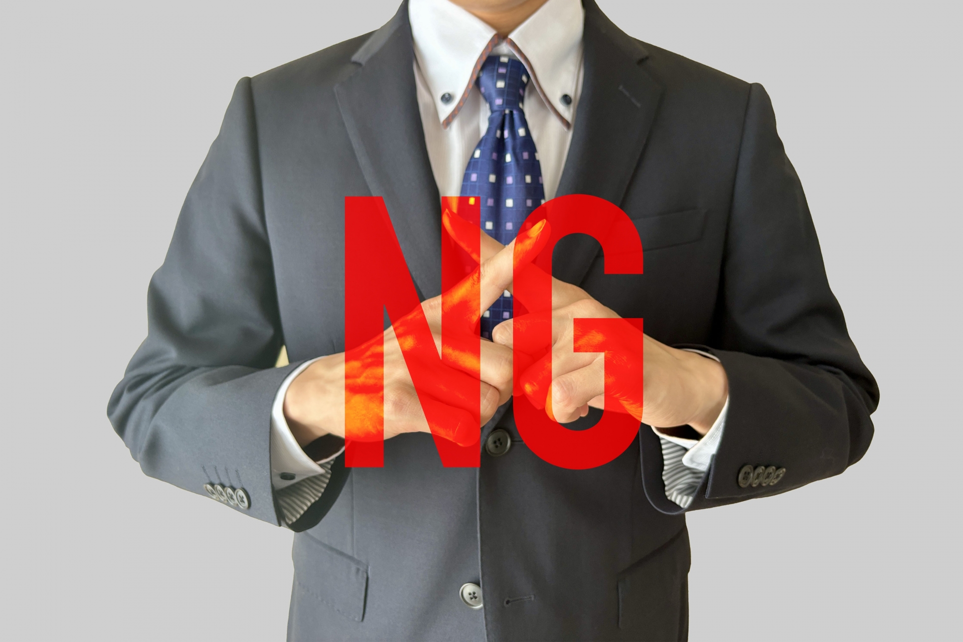 NGの文字とバツマークのポーズをする男性